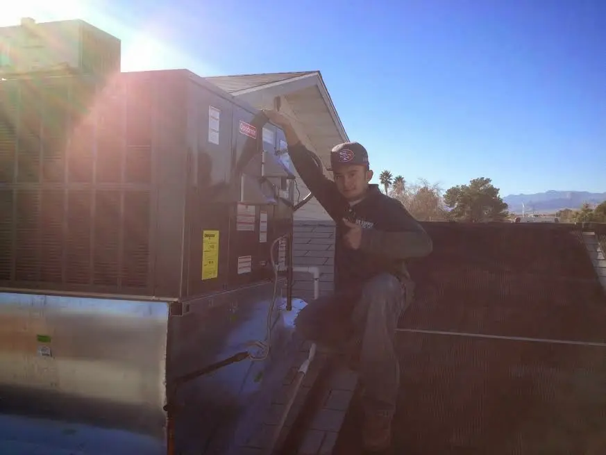 HVAC technician performing AC Tune-Up on a rooftop unit in Camden